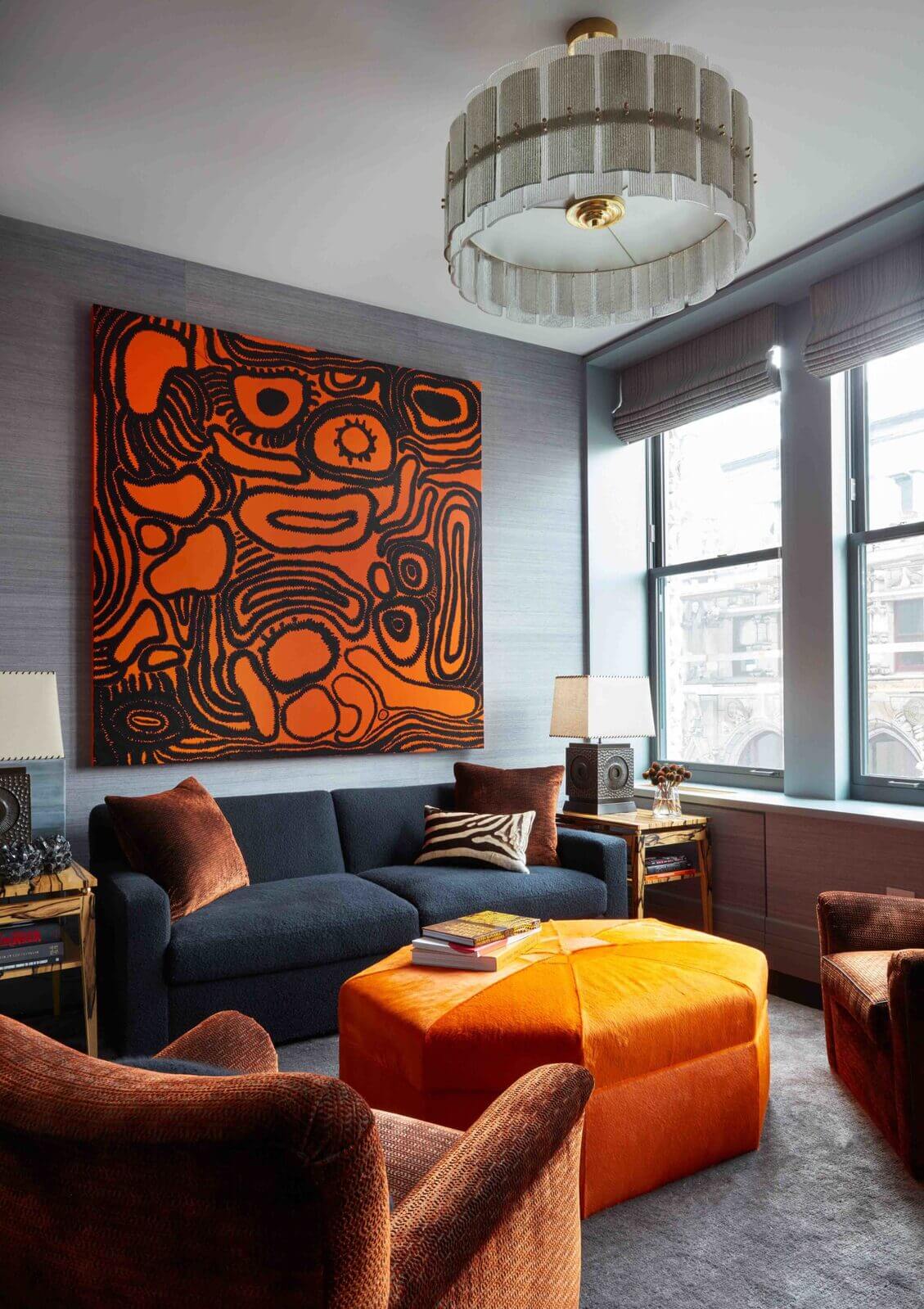 A small living room with gray walls and orange armchairs