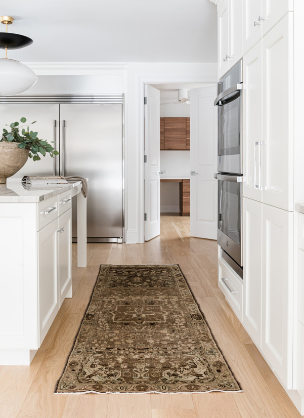 Kitchen with white furniture and a brown carpet on the floor