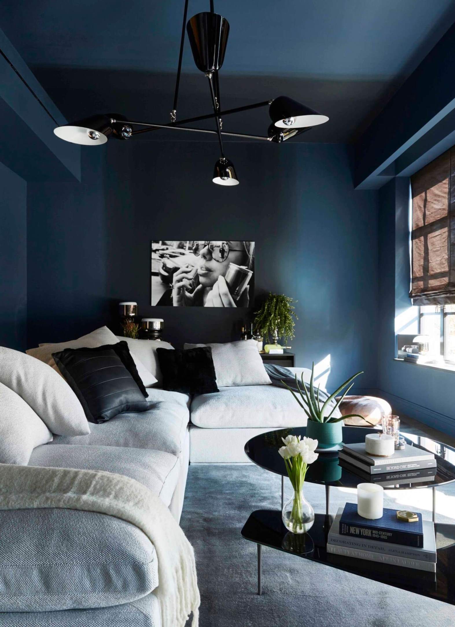 Living room with deep dark blue walls and a white corner couch