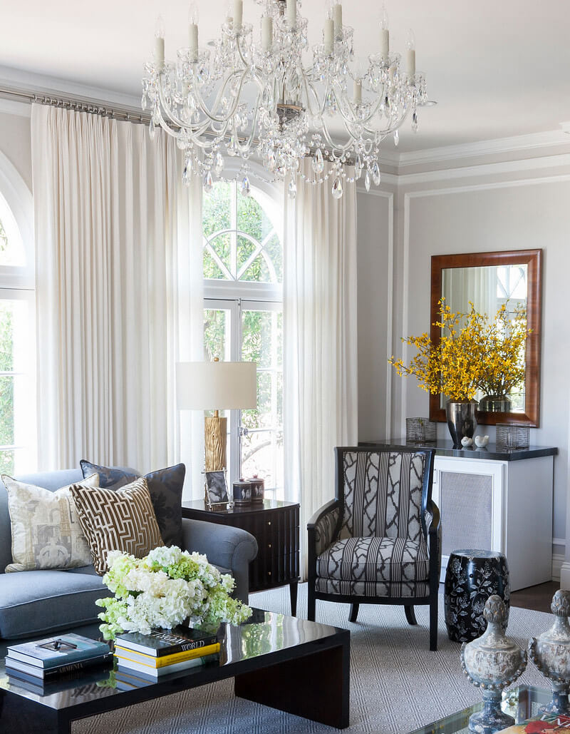 Living room with white walls and curtains, and dark accents