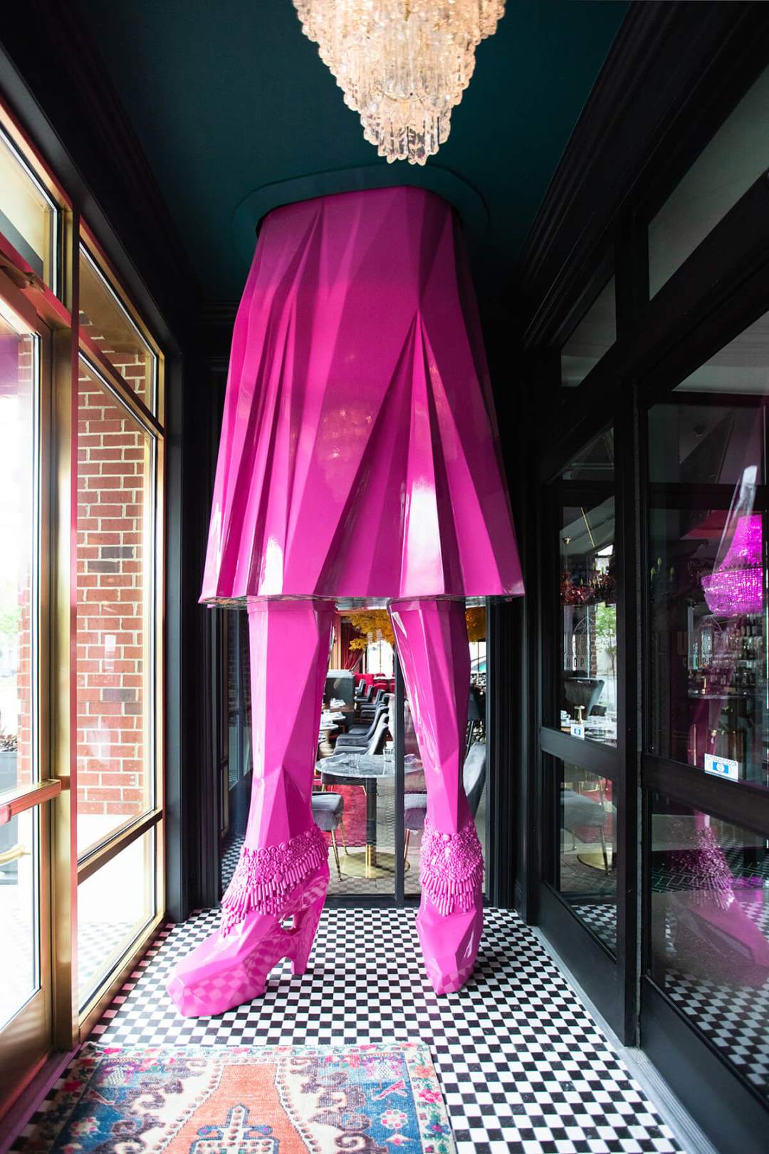 A large pink figure of a woman in a skirt and high heels in the hall
