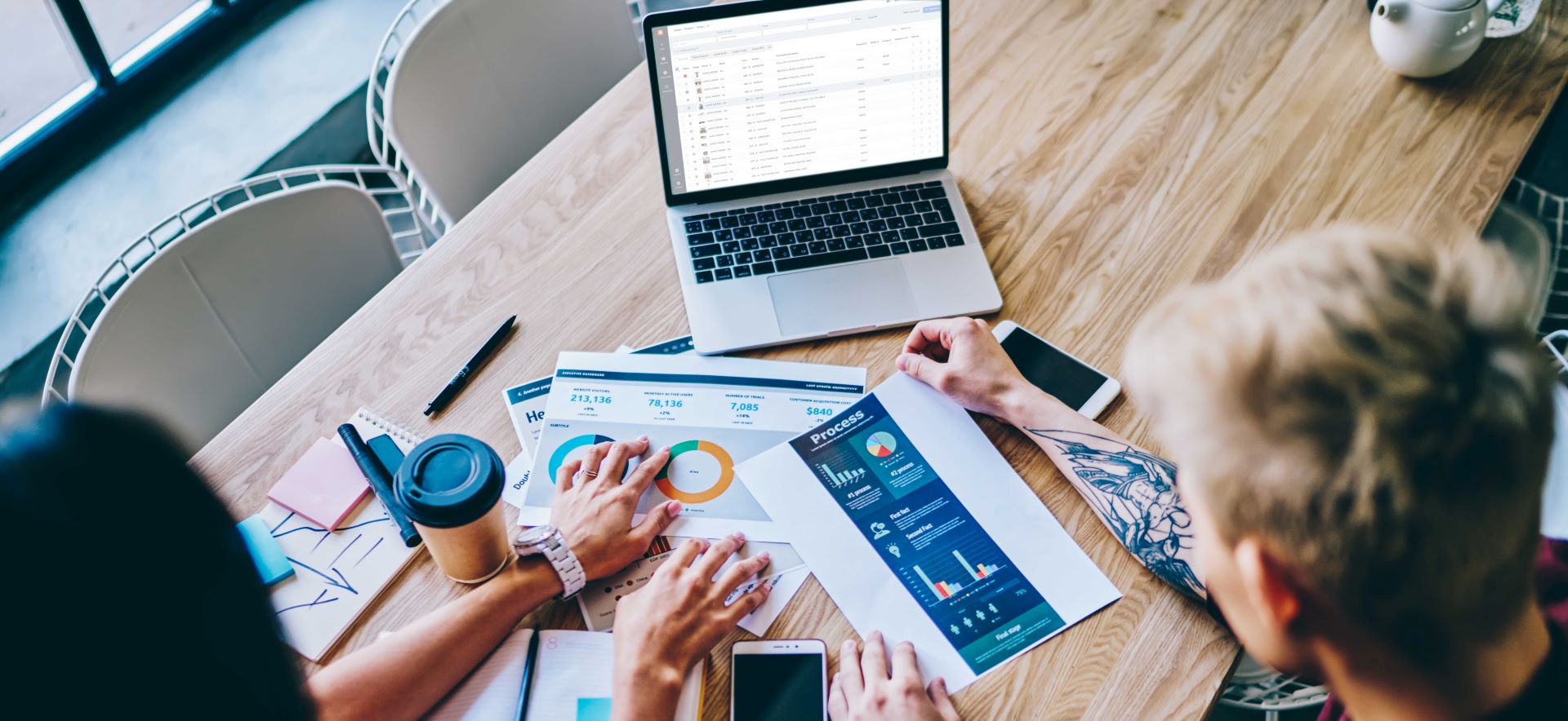 Two people look at charts and documents in the office