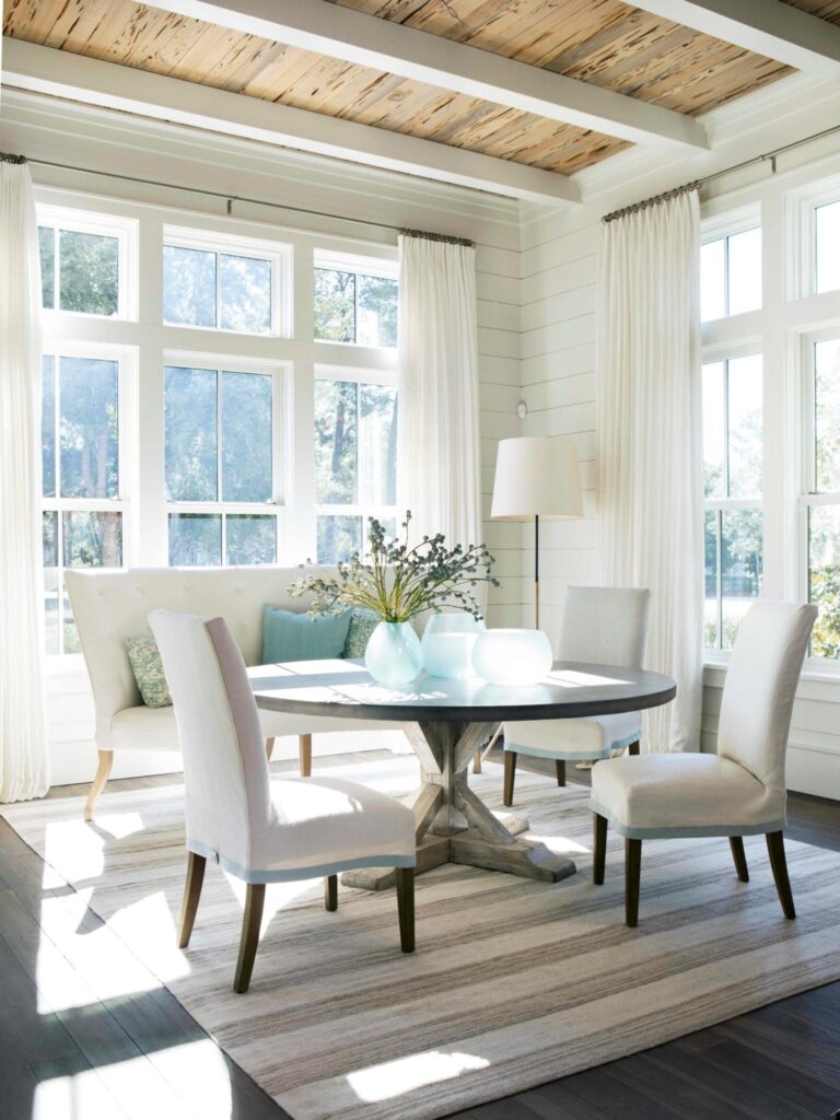 Round table with chairs in the dining room with large windows