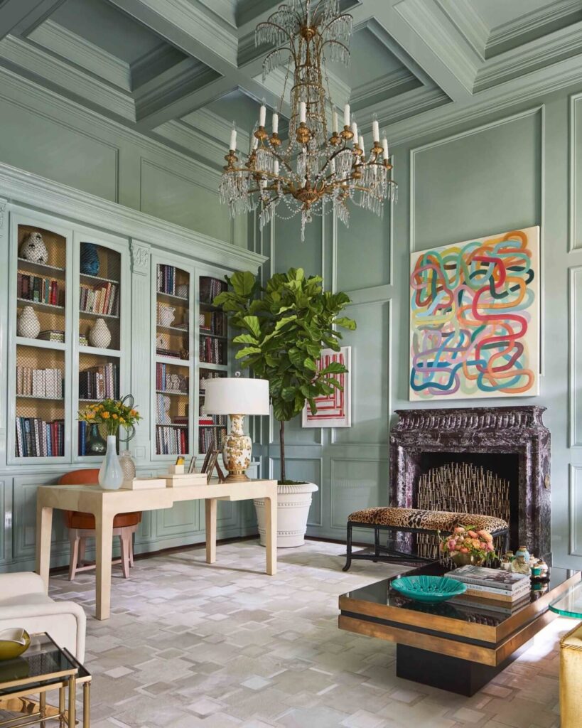 A home office with mint-colored walls, bookcases and a fireplace